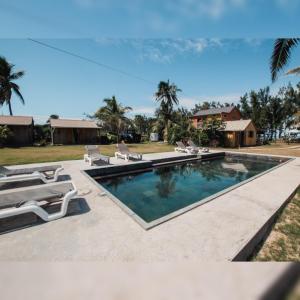 una piscina con 2 tumbonas junto a una casa en Gravier beach house en Rodrigues Island