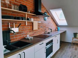 a kitchen with a sink and a brick wall at Gołubski Loft in Gołubie
