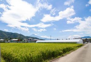 a large white building in a field next to a road at Erable Mt.Fuji "Kaze" in Fujikawaguchiko