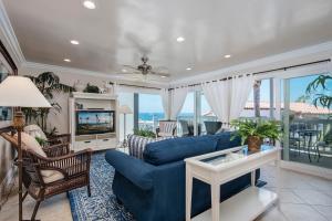 a living room with a blue couch and a tv at Monterey A in San Clemente