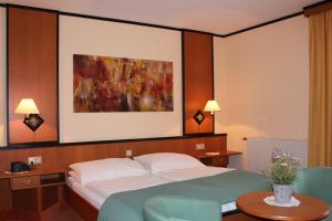 una camera d'albergo con un letto e un dipinto sul muro di Landgasthof Hotel Muhr a Gallbrunn