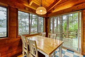a dining room with a table and chairs and windows at Lohman Lookout in Eastsound