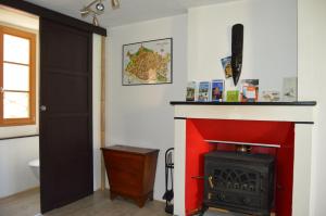 um quarto com uma lareira vermelha e uma porta preta em Le gîte du Bessat em Le Puy-en-Velay