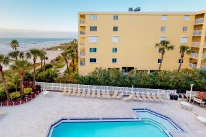 uma vista para a piscina e para a praia a partir da varanda de um resort em Beach Palms em Clearwater Beach