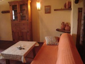 a room with a couch and a table and a door at Las 4 Lunas in Zahara de la Sierra