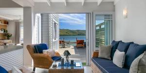 a living room with a blue couch and a balcony at On the water - Thesen in Knysna