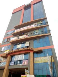 un edificio alto con letreros a un lado. en Shangri-La Fortune Hotel en Kampala