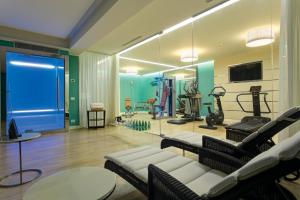 un gimnasio con sofá, sillas y espejo en Savoia Excelsior Palace Trieste - Starhotels Collezione, en Trieste