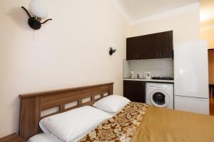 1 dormitorio con 1 cama y lavadora en Prestige Apartments na Vasilievskom, en San Petersburgo