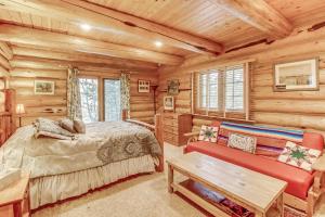 a bedroom in a log cabin with a bed and a bench at Oden Bay Log Home in Sandpoint