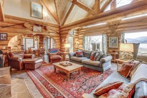 a living room filled with furniture in a log cabin at Oden Bay Log Home in Sandpoint