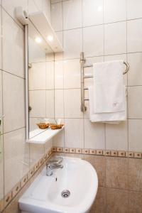 a bathroom with a white sink and a mirror at Prestige Apartments na Vasilievskom in Saint Petersburg