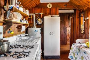 Il comprend une cuisine équipée d'une cuisinière et d'un réfrigérateur. dans l'établissement Rustic Rockport Cottage, à Rockport