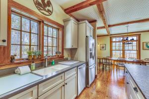 a kitchen with white appliances and wooden floors and windows at Lake Rescue Retreat in Ludlow +74 photos