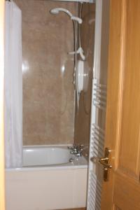 a bathroom with a shower with a tub and a sink at The Gremlin Lodge in Brecon