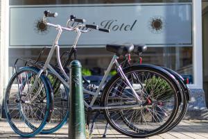 duas bicicletas acorrentadas a um poste em frente a uma loja em Sleep&Stay Floris IV em Haia