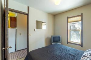 ein Schlafzimmer mit einem Bett und einem TV in der Unterkunft Red Cricket 22 in Sandpoint
