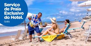 um grupo de pessoas sentadas na praia em Monte Pascoal Praia Hotel Salvador em Salvador