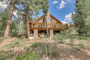 a log home with a wrap around deck in the woods at Heaven's Gate in Durango