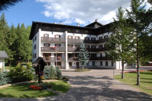 um grande edifício com uma estátua em frente em Casa Santa Maria em Folgaria