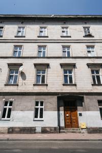 克拉科夫Cosy Place - LoftAffair的一座带窗户和木门的大型建筑