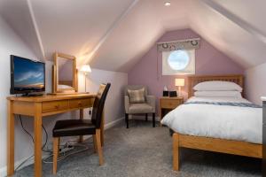 a bedroom with a bed and a desk with a computer at Bodnant Guest House in Llandudno