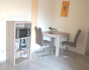 a room with a table and two chairs and a microwave at APPartementWESTiNGhaus in Edemissen