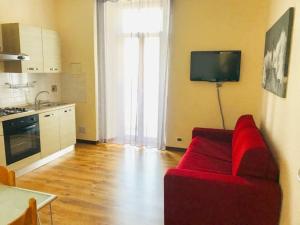 a living room with a red couch and a kitchen at Violamare in Savona