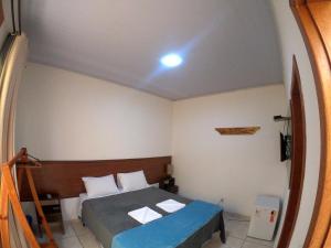 a small bedroom with a bed with a blue blanket at Pousada Marotta in Ouro Preto