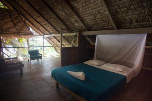 Schlafzimmer mit einem Bett mit blauer Decke in der Unterkunft Punta Brava in Nuquí