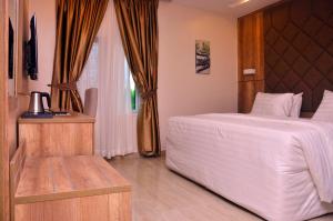 a bedroom with a large white bed and a window at Lit Suites in Abuja