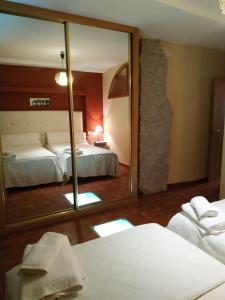 sypialnia z dużym lustrem i łóżkiem w obiekcie Apartamentos Arribes la Corredera w mieście Aldeadávila de la Ribera