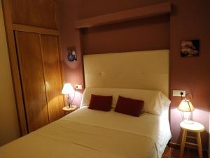 sypialnia z białym łóżkiem z 2 lampami w obiekcie Apartamentos Arribes la Corredera w mieście Aldeadávila de la Ribera