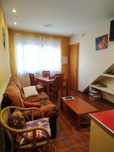 salon z kanapą i stołem w obiekcie Apartamentos Arribes la Corredera w mieście Aldeadávila de la Ribera