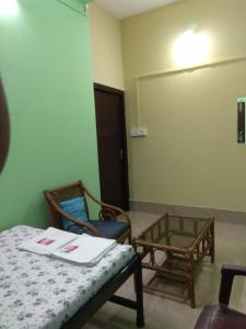 a room with chairs and a table and a door at Cozy Living in Guwahati