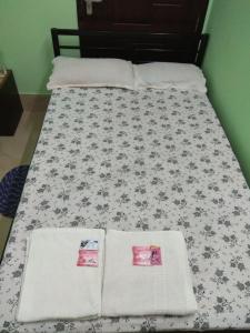 a bed with a black and white comforter and two pillows at Cozy Living in Guwahati