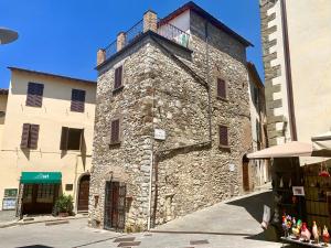 um velho edifício de pedra no meio de uma rua em ART REBUS Tower in Tuscany em Radda in Chianti