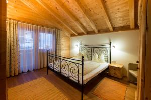 ein Schlafzimmer mit einem schwarzen Bett und einer Holzdecke in der Unterkunft Feriendorf Wildschönau in Niederau