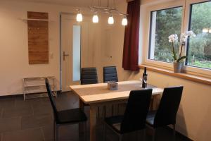 a kitchen with a table and chairs with a bottle of wine at Haus in der Kurve in Kappl