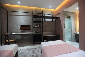 a bedroom with two beds and a desk and a sink at Zenvea Hotel in Coron
