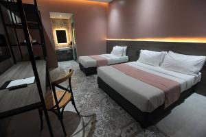 A bed or beds in a room at Zenvea Hotel