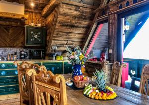 a wooden kitchen with a table with fruit on it at Chalupa Chalet Strachan in Ždiar