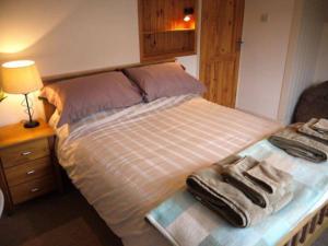 a bedroom with a bed with two towels on it at Jimmer's Loft in Cadgwith