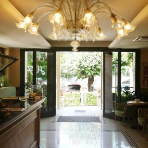 a dining room with a chandelier and a hallway at Hotel Fioroni in Bellagio