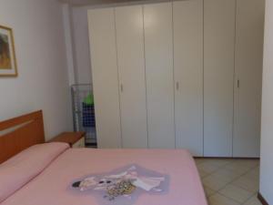 - une chambre avec un lit rose et des placards blancs dans l'établissement lidoapartment, à Fano