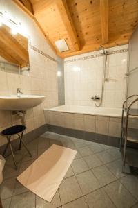 uma casa de banho com uma banheira e um lavatório e uma banheira em Feriendorf Wildschönau em Niederau