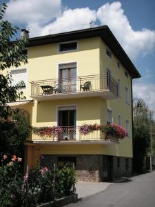 ein gelbes Gebäude mit Balkonen und Blumen darauf in der Unterkunft Casa Ferrari Michela in Calceranica al Lago