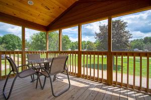 a screened in porch with a table and chairs on it at O'Connell's RV Campground Deluxe Park Model 38 in Inlet +6 photos