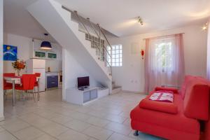 a living room with a red couch and a table at apartman Nataša in Mali Lošinj