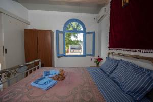 een slaapkamer met een bed en een open raam bij Castri House in Matala